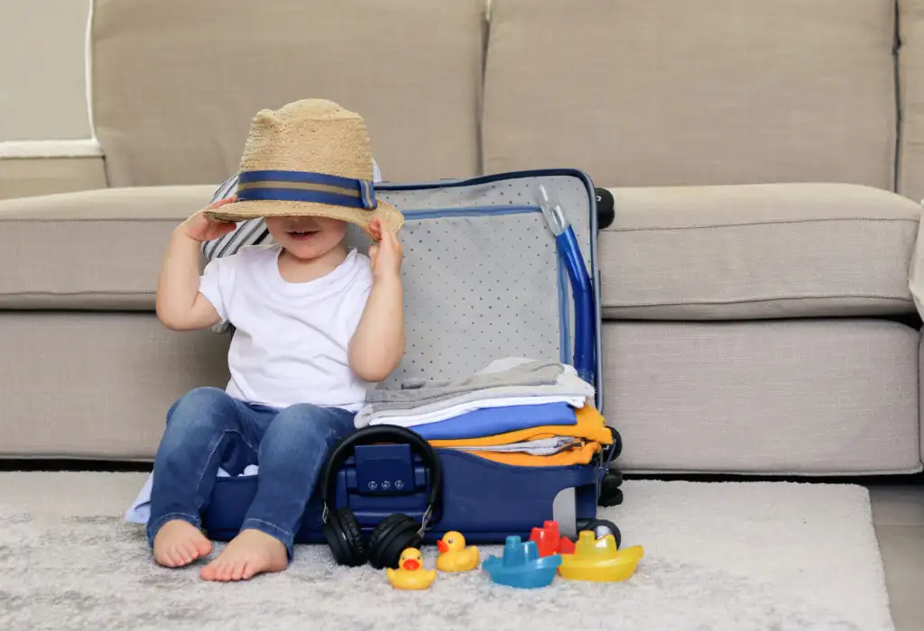 Child playing in packed suitcase