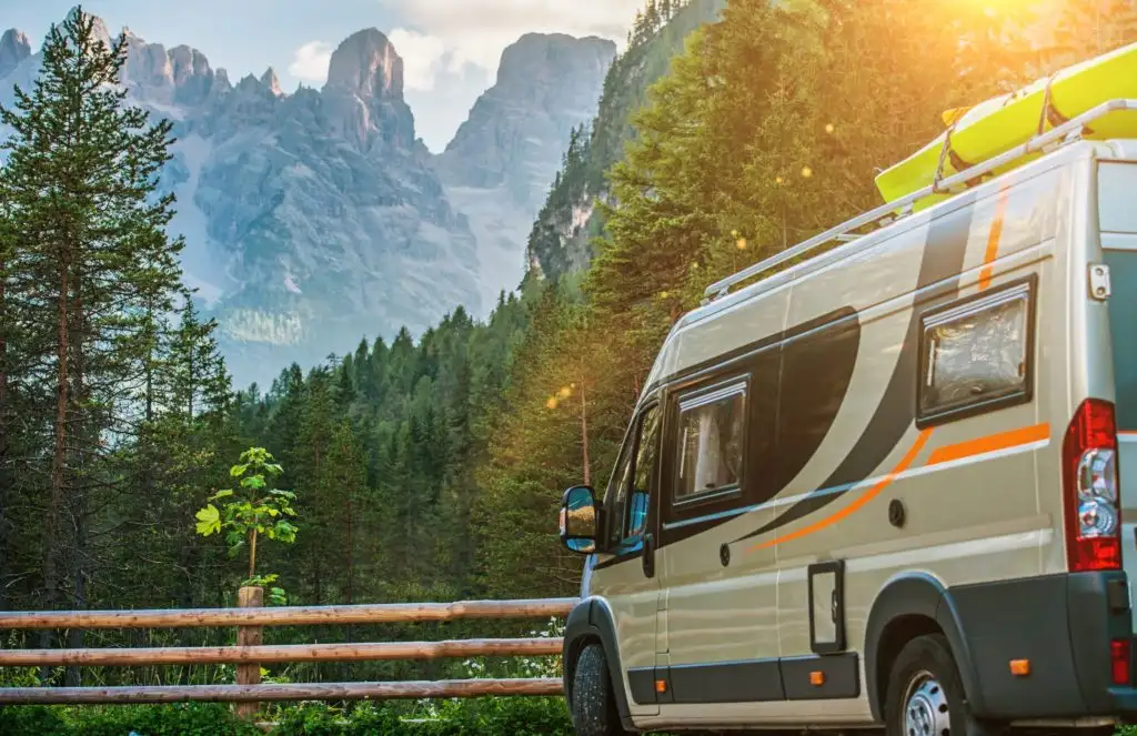 Class B Motorhome parked in front of a green forest