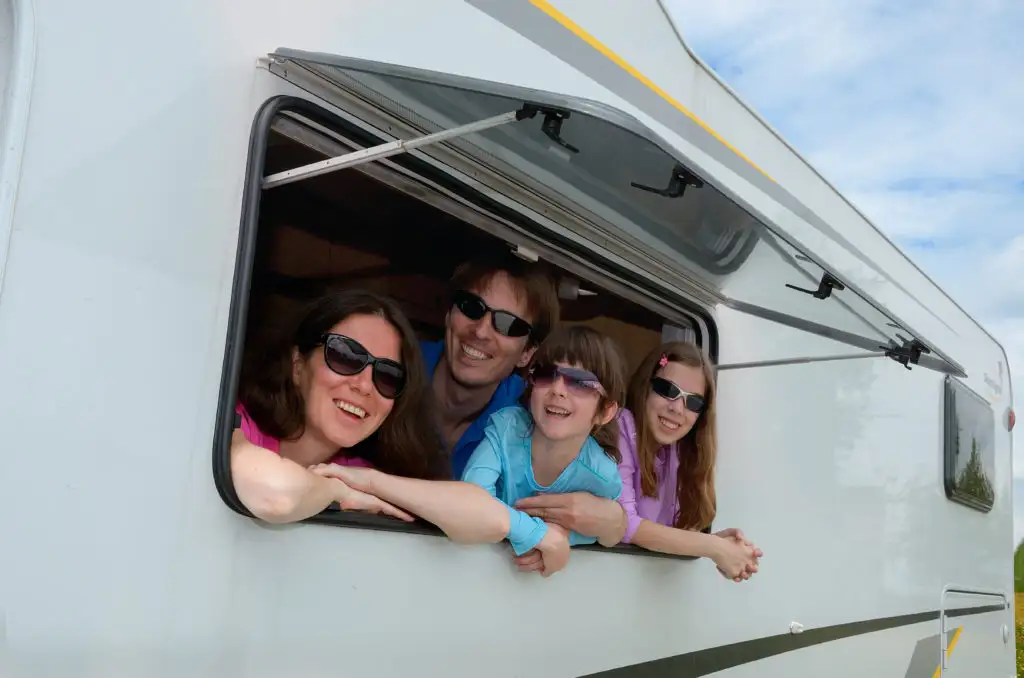 Family leaning out of the window of their RV