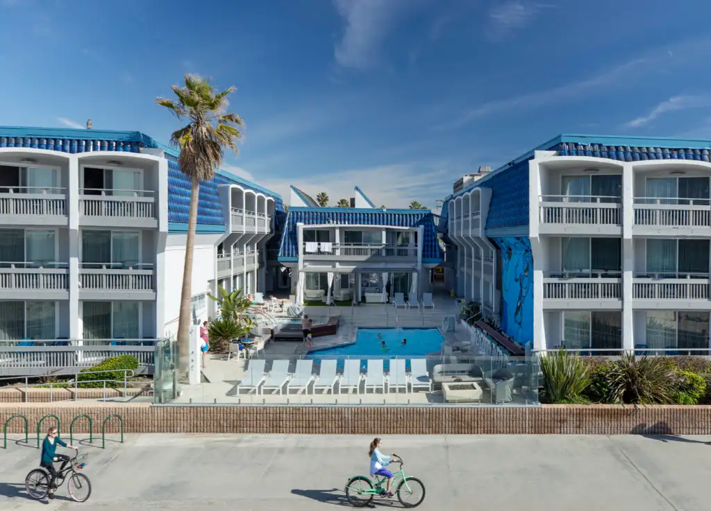 People biking in front of the Blue Sea Beach Hotel