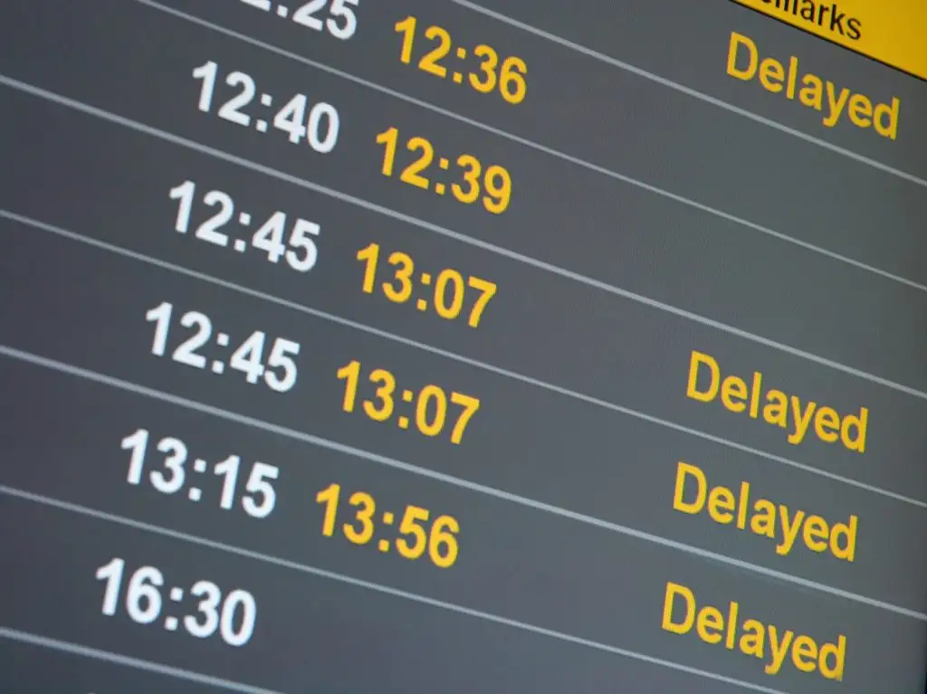 Airport departures board showing delayed flights