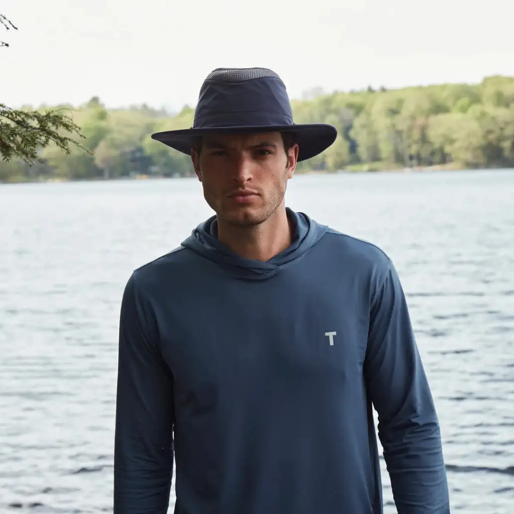 Man standing by lake wearing Tilley LTM6 Airflo Hat
